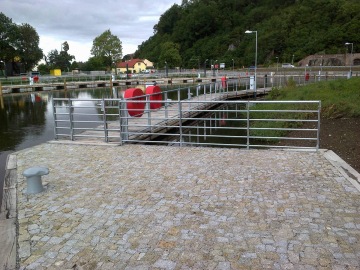 Ochranné ocelové konstrukce přístavních zdí, zábradlí včetně příslušenství po obvodu přístavního bazénu a ostatní zámečnické prvky včetně úvazníků, tzv. pacholat.