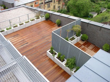 Střešní terasa s kovovými dělícími stěnami a dalšími zámečnickými prvky.