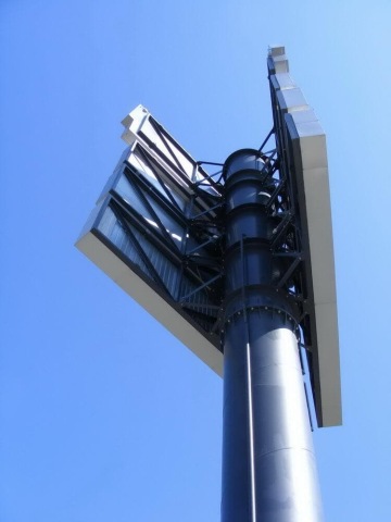 Velký kovový billboard OC Géčko směřující k modré obloze.