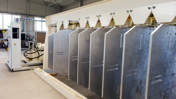 Průmyslové zařízení s kovovými panely v tovární hale.