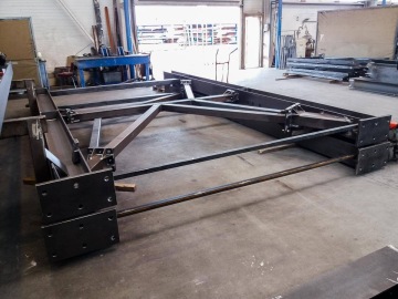 Velká kovová rámová konstrukce pod sila připravená k montáži nebo použití.