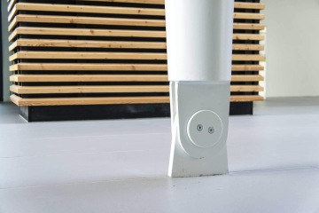 Bílý ocelový sloup na podlaze před dřevěnou mřížkouv Laserovém centru ELI.