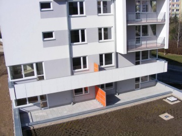 Moderní bytový dům Milíčovský háj s balkonem a oranžovými poštovními schránkami.