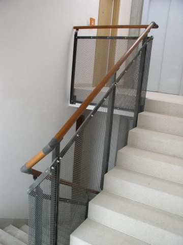 Světlé schodiště s dřevěným madlem a kovovým zábradlím Dolní Břežany.