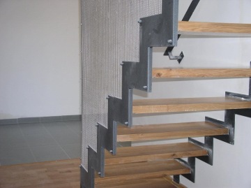 Moderní vnitřní schodiště s dřevěnými stupni a kovovým zábradlím.