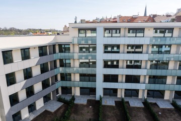 Moderní bytový dům s terasovými zábradlími – se skleněnou výplní a s výplní z kompaktní desky.