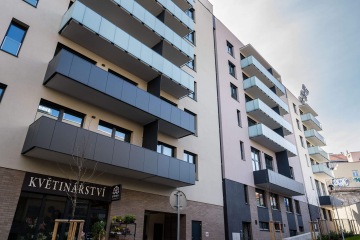 Moderní bytový dům s terasovými zábradlími – se skleněnou výplní a s výplní z kompaktní desky.