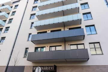 Moderní bytový dům s terasovými zábradlími – se skleněnou výplní a s výplní z kompaktní desky.