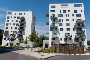 Kovové zábradlí balkonů v elegantním antracitovém odstínu, přístřešek na odpad.