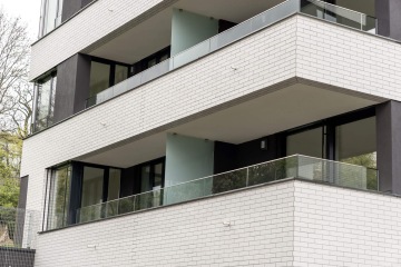 Moderní bytový dům Rezidence U Sluncové s velkými prosklenými balkony.