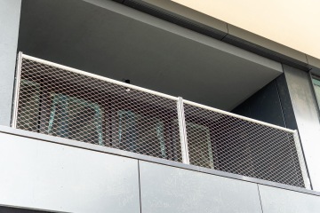 Balkón Vanguard Praha s kovovým pletivem a skleněnými dveřmi.