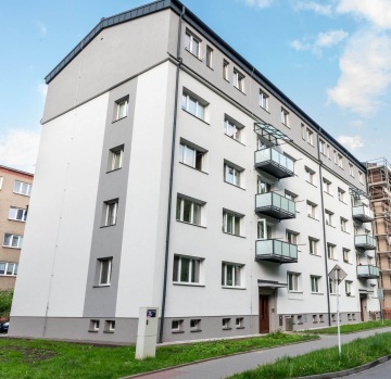Moderní bytový dům BD Palackého Třinec s balkony, šedobílá fasáda, světlý den.