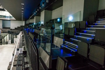 Prázdná moderní tribunová sedadla s modrým podsvícením v sále O2 Universum Praha.