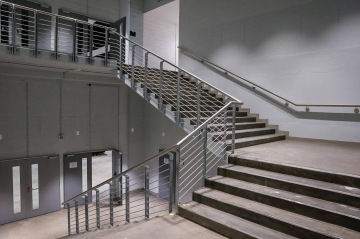 Betonové schodiště s kovovým zábradlím v moderní budově O2 Universum Praha.