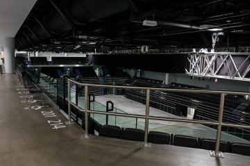 Prázdná hala O2 Universum Praha s ocelovou konstrukcí a sedačkami, pohled z balkonu.