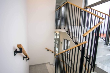 Vnitřní schodiště administrativní budovy s vnitřním zábradlím.
