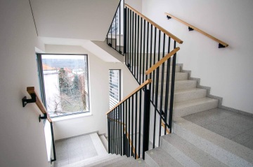 Vnitřní schodiště administrativní budovy s vnitřním zábradlím.