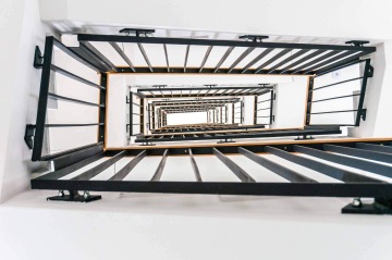 Vnitřní schodiště administrativní budovy s vnitřním zábradlím.