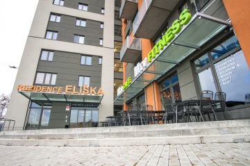 Budova Rezidence Eliška s nápisy na fasádě a venkovním sezením.