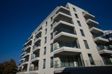 Moderní bytový dům BD 4U Living s balkony a modrou oblohou.