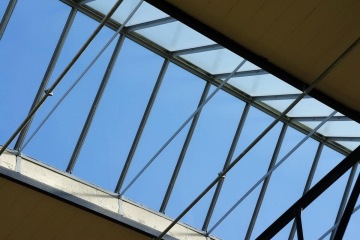 Střešní prosklení Kaufland Podbaba s kovovou konstrukcí a modrou oblohou v pozadí.