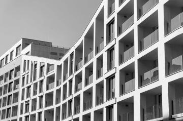 Moderní bytový dům BD Port Karolína, Praha s balkony a velkými okny v černobílém provedení.