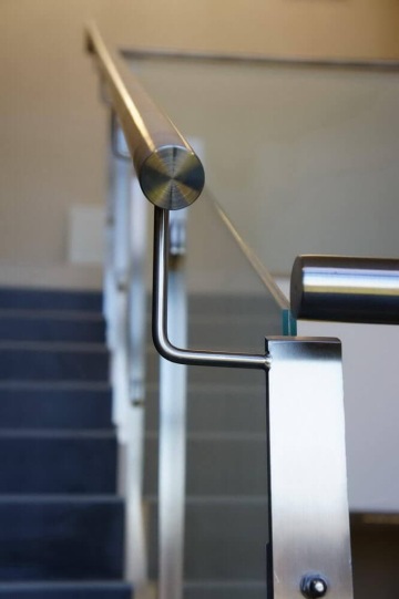 Vnitřní kovové zábradlí u moderního schodiště.