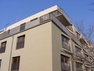 Moderní bytový dům Pod Tyršovým vrchem s balkóny za jasného dne.