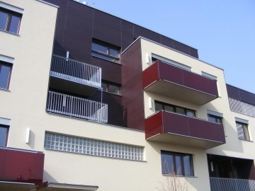 Moderní bytový dům Mazanka s balkony a prosklenými prvky na fasádě.