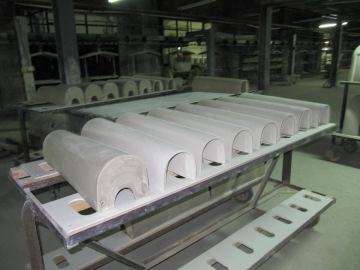 Výroba sanitární keramiky ve výrobní hale na kovovém stole.