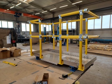 Plně sestavená žlutá bezpečnostní zábradlí na kovové plošině v dílně.