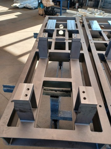 Kovový rám s pevnými montážními body v dílně, připravený k dalšímu zpracování.