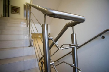 Nerezové zábradlí na schodišti s moderním designem a čistými liniemi.