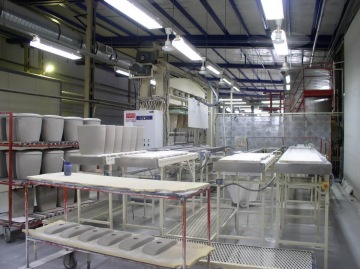 Stroj pro výrobu sanitární keramiky technologií tlakového lití do porézních plastových forem.