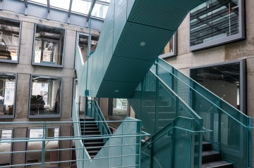 Moderní kovové schody v proskleném vnitřním atriu budovy.