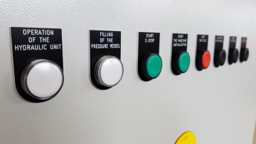 Tlačítka na ovládacím panelu s popisy pro hydraulickou jednotku, plnění tlakového nádoby a spuštění.